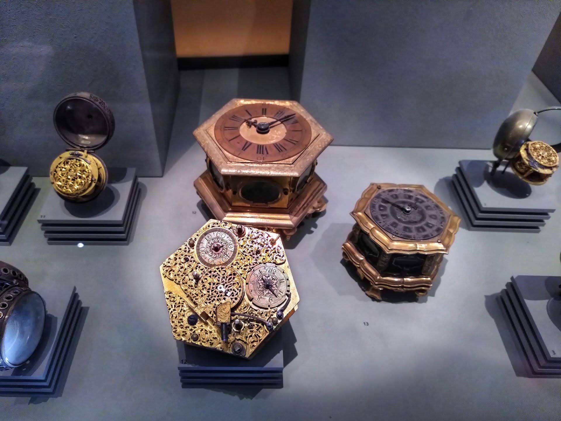 A variety of timepieces on display, those in the center have a hexagonal shape